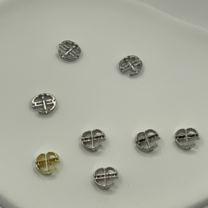 Minimalist Round Silhouette with Intricate Hollow-Out Details These decorative buttons feature a clean, modern round shape with varied hollow-out designs, finished in smooth, reflective silver or gold tones. The understated yet detailed aesthetic complements both casual and chic fashion styles, adding a refined, contemporary flair to any outfit.